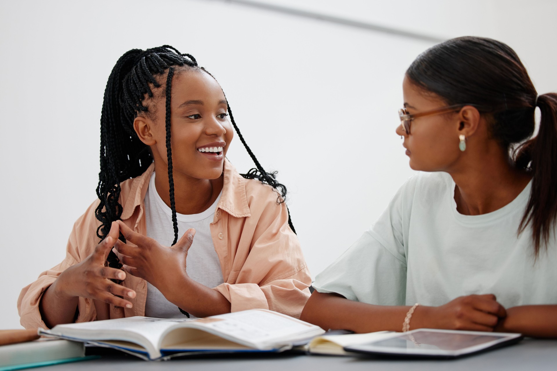Education, friends and study with girl learning on books and digital tablet in a home, distance learning and school project.  Student, help and tutor for university preparation with young learners