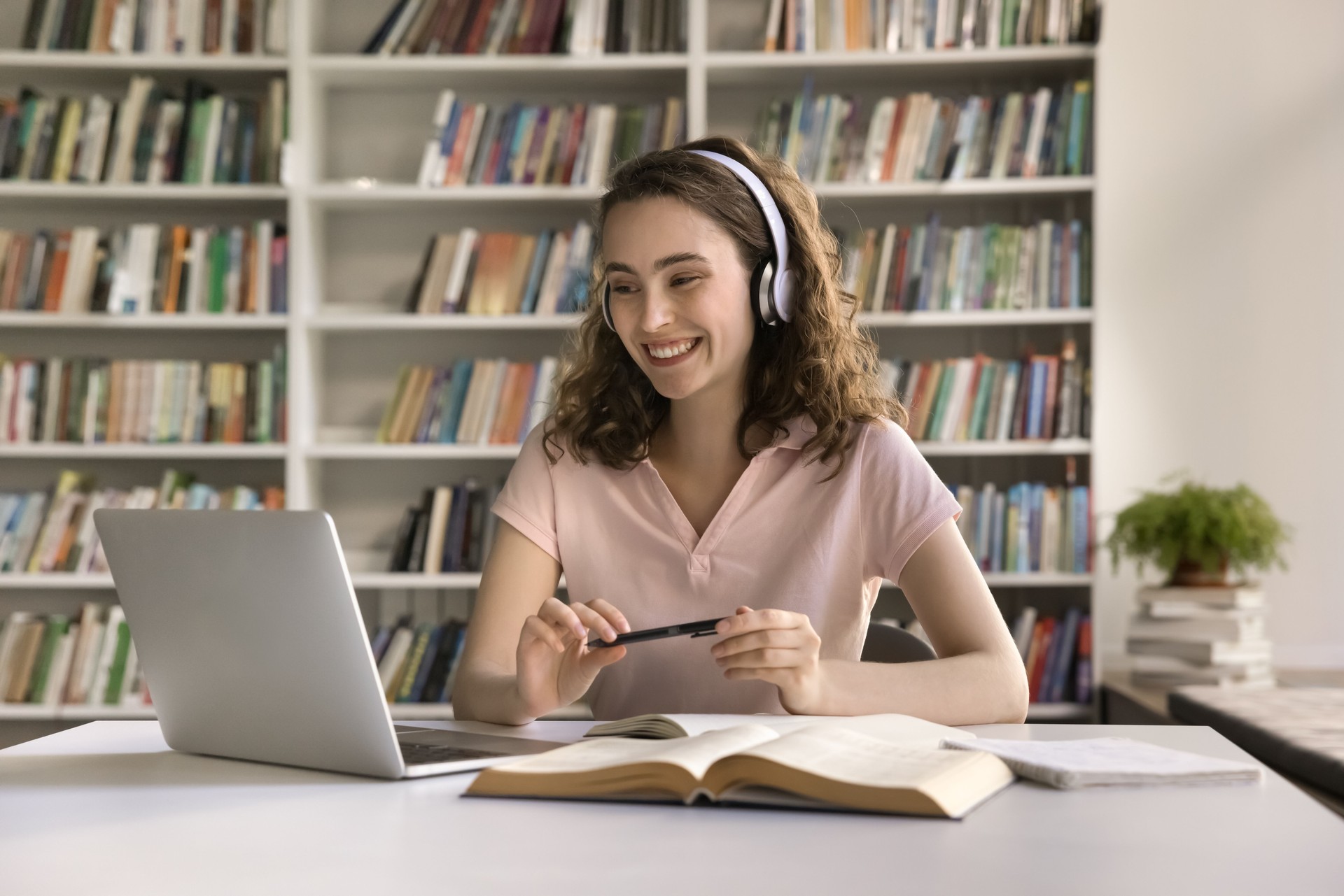 Happy girl in headphones engaged in on-line class